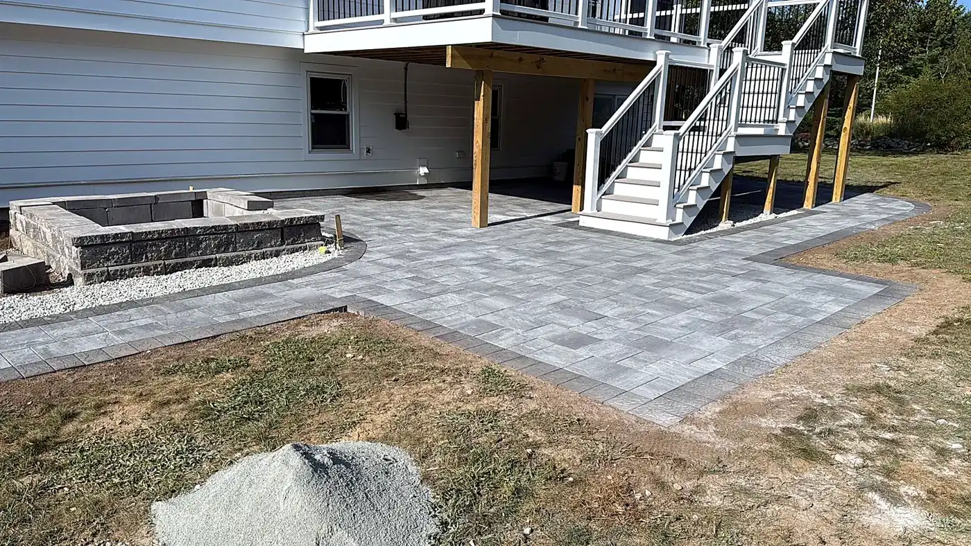 Compact bluestone patio with planting beds in a small fenced backyard